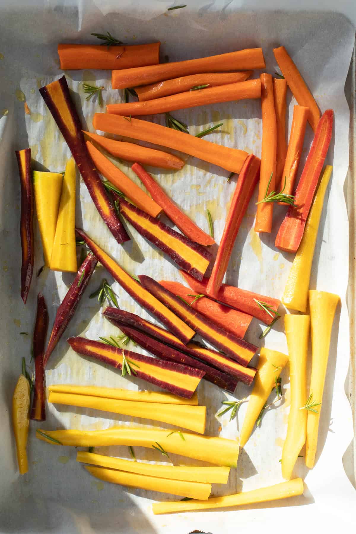 cut carrots on a baking sheet drizzled with olive oil and rosemary.
