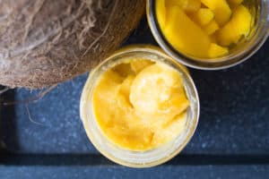 Coconut, mango cubes and mango ice cream on a black tray