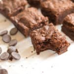 brownie with bite taken out of it next to chocolate chips