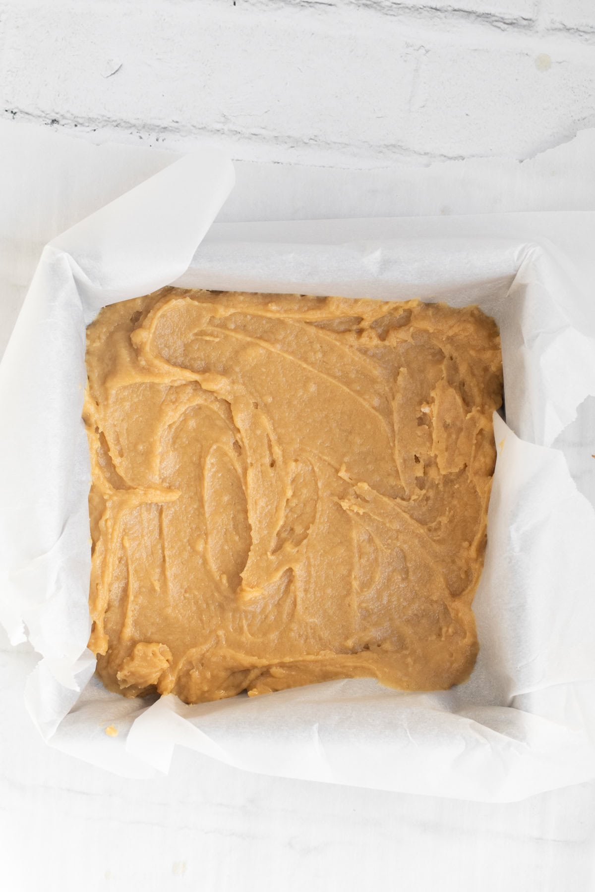 blondie batter in a parchment lined baking pan.