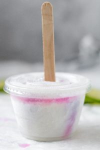 coconut lime popsicle in a 5 oz plastic portion cup with lid.