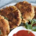 salmon patties on a plate in a circle with ketchup in the middle