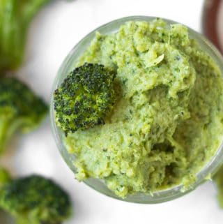 broccoli puree in a small mason jar with roasted broccoli surrounding it