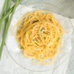 small plate of sesame noodles garnished with whole scallions