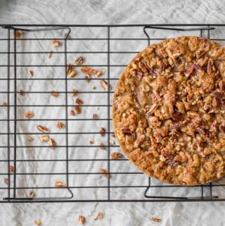 sweet potato pie on a cooling rack with nuts underneath