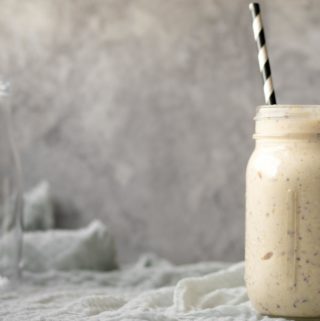 smoothie in a mason jar with an empty milk jar in the background
