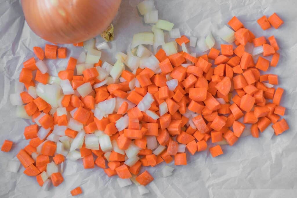 chopped carrots and onion on parchment paper