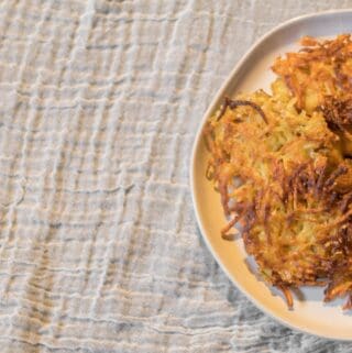 potato latkes on a plate with applesauce