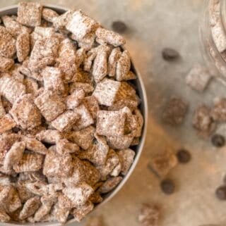 puppy chow in a big bowl with a scoop of peanut butter