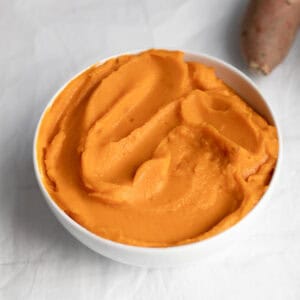 Sweet potato puree in a white bowl.