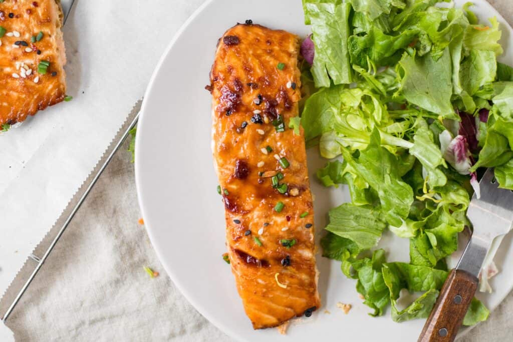 piece of sesame ginger salmon on a plate with salad