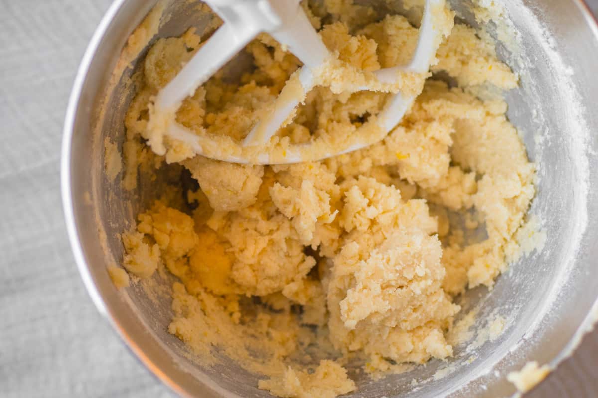 lemon shortbread cookie dough in a stand mixer with paddle atachement