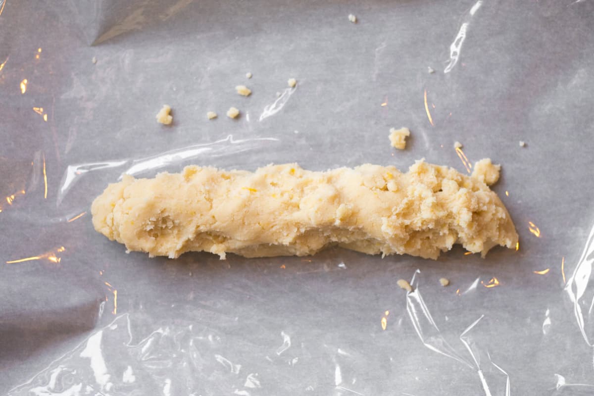 log of dough laying on cling wrap