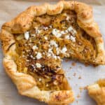 caramelized onion and goat cheese tart with a slice cut out of it