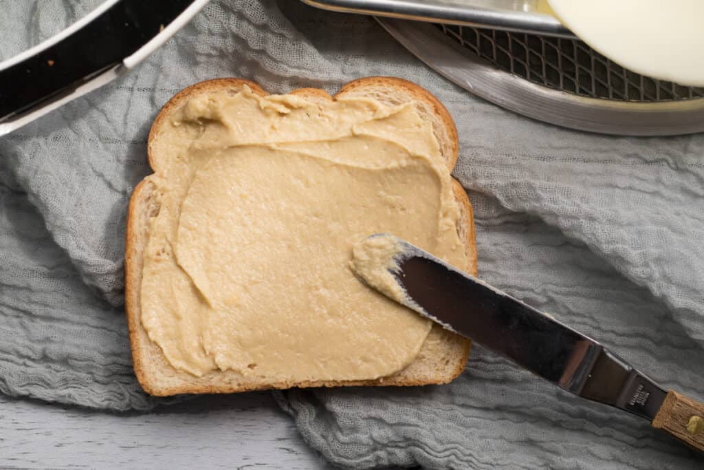 hummus spread on a piece of wheat bread