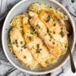 fish piccata in a bowl with a spoon