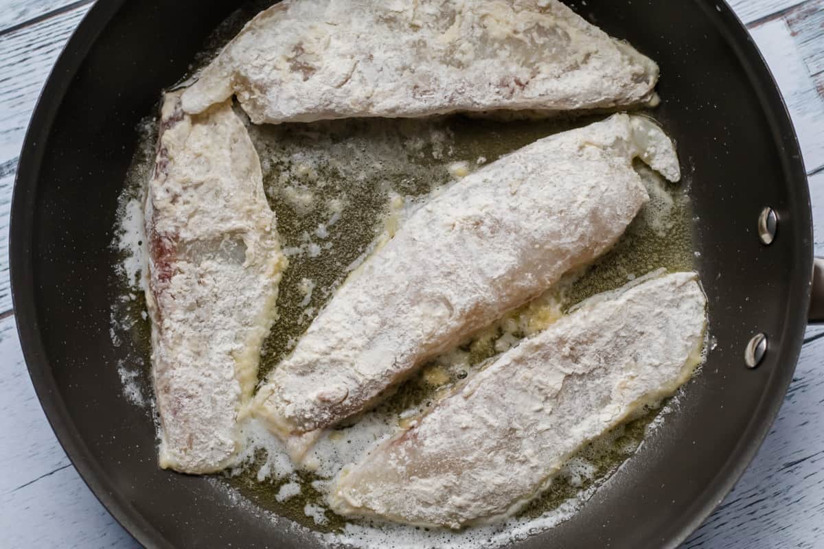 fish frying in a pan