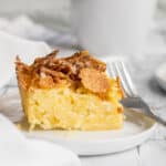 noodle kugel on plate with a fork and mug in background