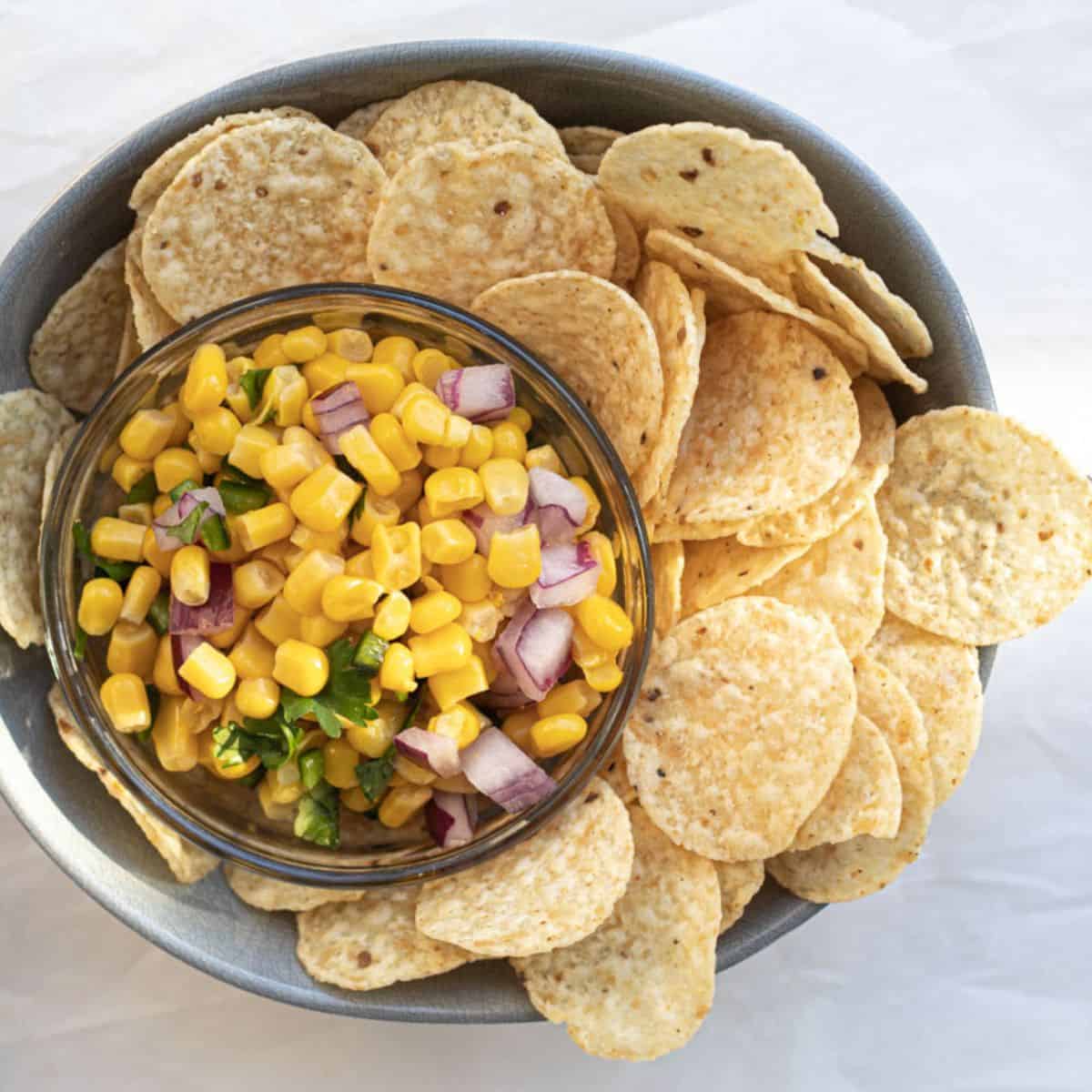 chipotle corn salsa in a small bowl surrounded by corn chips