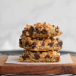 3 hello dolly bars stacked on a wooden serving piece