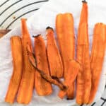 strips of carrot bacon on parchment paper on a cooling rack