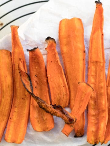 strips of carrot bacon on parchment paper on a cooling rack