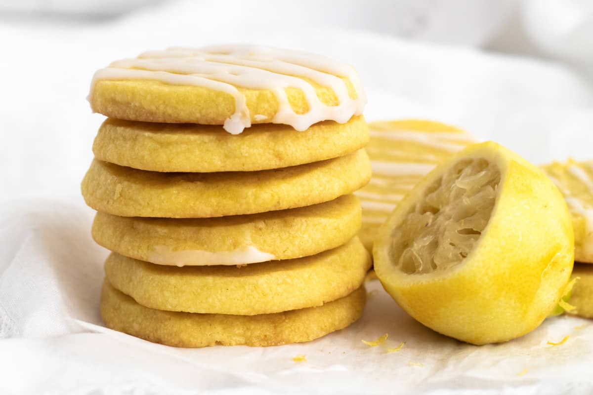 a stack of lemon shortbread with a zested lemon next to it