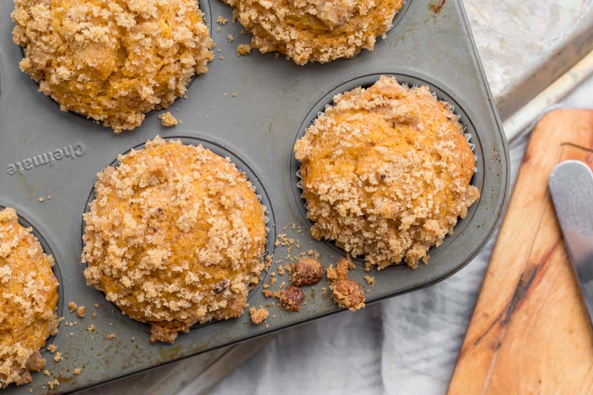 pumpkin muffins with streusel in a muffin tin