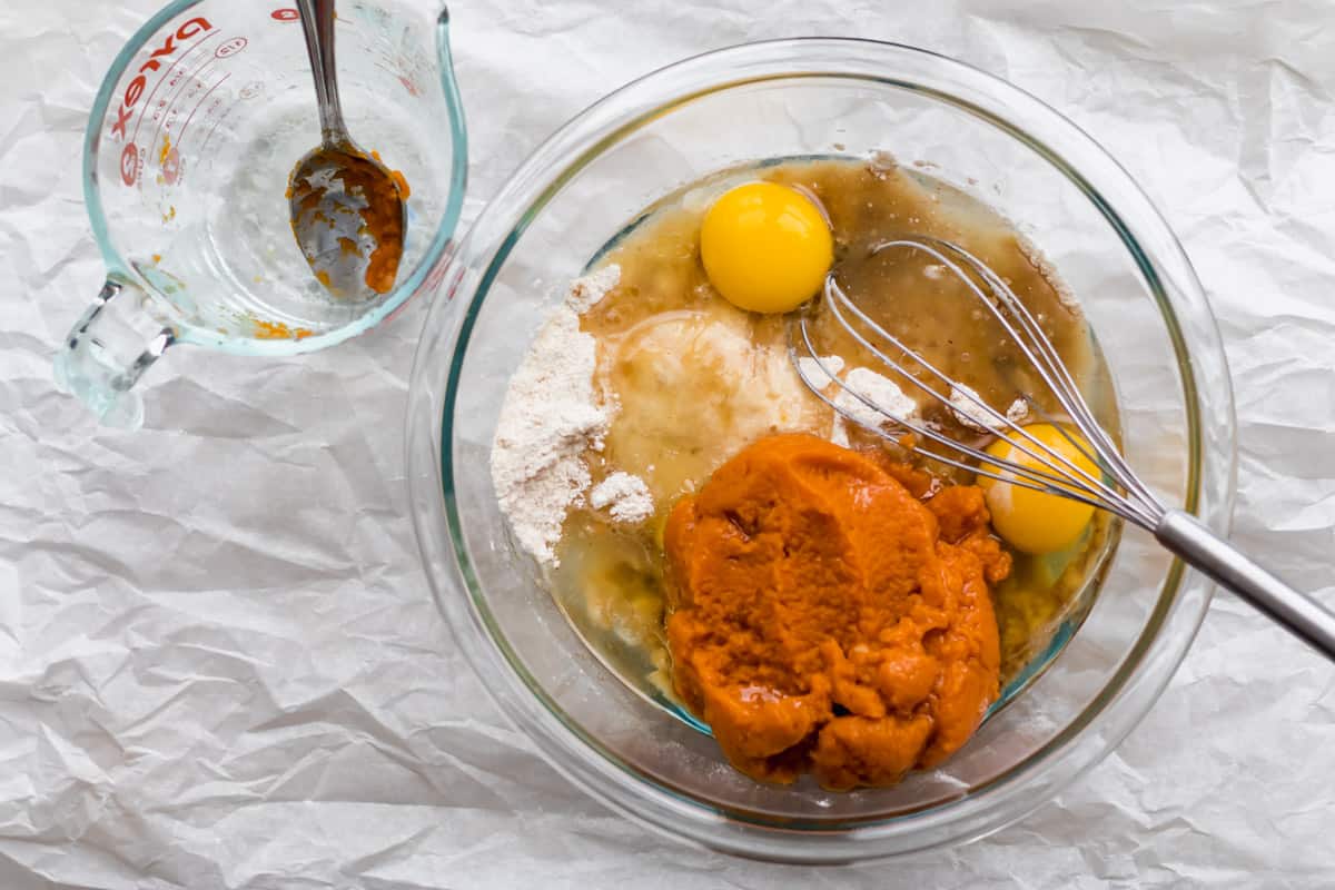 adding wet ingredients into a mixing bowl
