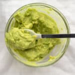 avocado puree in a glass bowl with a spoon