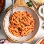 pink sauce pasta in a bowl with serving spoon
