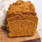 Sliced pumpkin bread on a wooden serving board