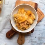 peach cobbler in a white bowl
