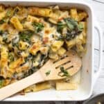 artichoke spinach baked pasta in a white baking dish