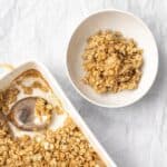 bowl of vegan baked oats next to the pan with a spoon