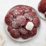 red velvet cookies dusted with powder sugar on a white plate