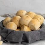 garlic rolls in a bread basket lined with a linen