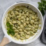 pesto gnocchi in a saute pan with basil