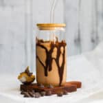 Peanut butter chocolate smoothie in a glass cup with chocolate drizzle