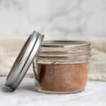 cinnamon sugar in a mason jar with the lid next to it.