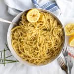 lemon butter pasta in a bowl garnished with a lemon