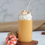 pumpkin smoothie with whipped cream and decorative pumpkins.