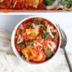 spinach ravioli pasta bake in a white bowl with a fork