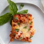 piece of matzo lasagna garnished with fresh basil
