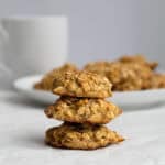 three banana breakfast cookies stacked with a plate of cookies behind