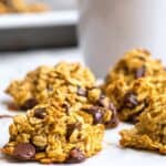 close up of chocolate chip breakfast cookie on a plate with mug behind