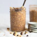 chocolate overnight oats in a mason jar with chocolate chips and oats around it
