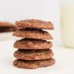 brownie mix cookies stacked 5 high with a glass of milk in background
