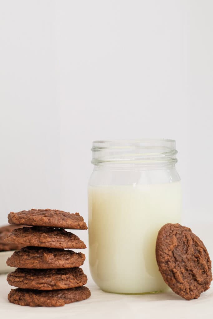 brownie cookies next to a glass of milk.