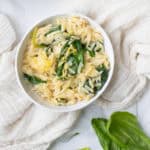 bowl of spinach lemon orzo in a white bowl